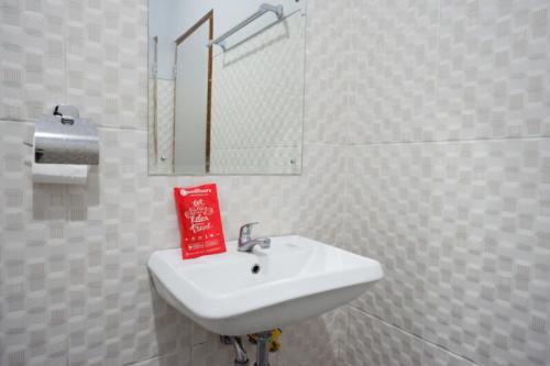 a bathroom with a white sink and a mirror at RedDoorz Syariah near Kawasan Sam Poo Kong 2 in Kalibanteng-kidul