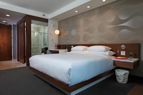 a hotel room with a large bed and a bathroom at Mere Hotel in Winnipeg
