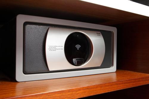 a small television sitting on top of a wooden shelf at Mere Hotel in Winnipeg