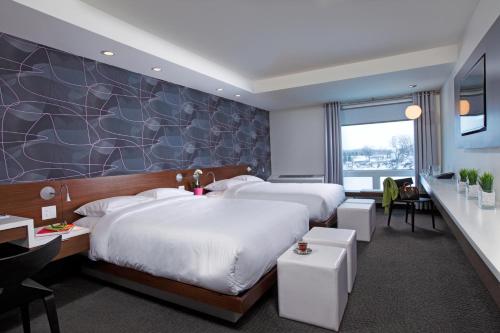 a hotel room with two beds and a desk at Mere Hotel in Winnipeg