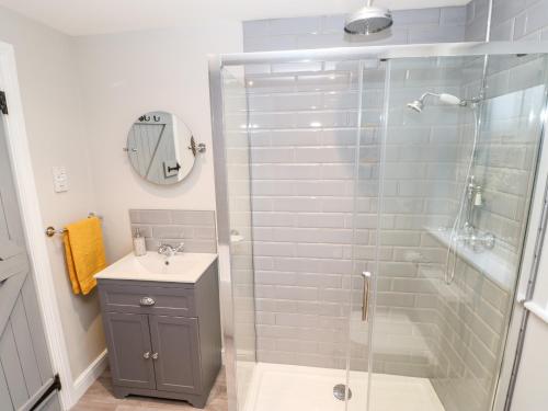 a bathroom with a glass shower and a sink at October Cottage in Barnard Castle