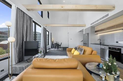 a living room with two couches and a table at Hobart City Apartments in Hobart