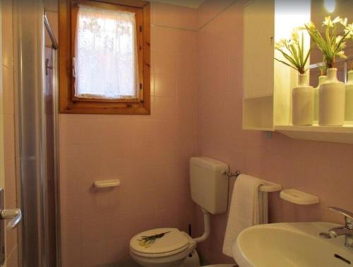 ein Bad mit einem WC und einem Waschbecken in der Unterkunft Bright flat in a poolside residence - Beahost in Bibione