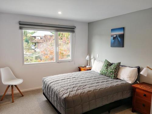 a bedroom with a large bed and a window at Aspiring Apartment Wanaka in Wanaka