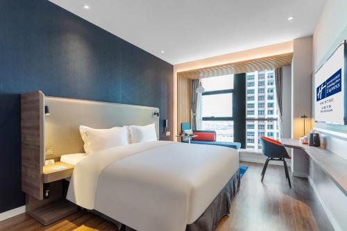 a hotel room with a large bed and a desk at Holiday Inn Express Dali Xiaguan by IHG in Dali