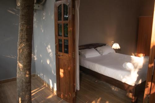 a bedroom with a bed and an open door at The Sovereign Villa in Candolim