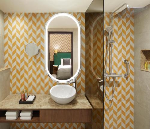 uma casa de banho com um lavatório e um espelho em The Connaught, New Delhi- IHCL SeleQtions em Nova Deli