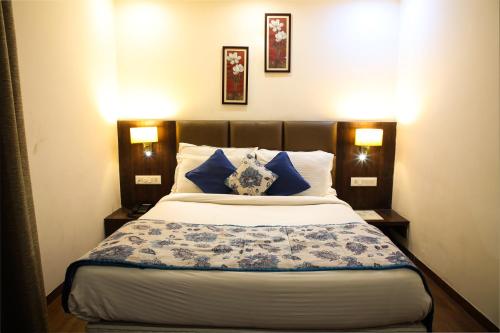 a bedroom with a bed with blue and white pillows at Riva Gold Coast in Candolim