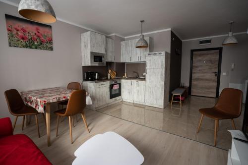 eine Küche und ein Wohnzimmer mit Tisch und Stühlen in der Unterkunft GUEST SUITE Narodno horo in Sofia