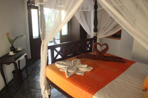 a bedroom with a bed with a flower on it at The Spice House Mirissa in Mirissa