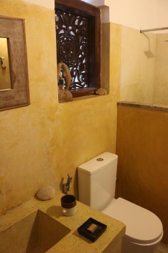 a bathroom with a white toilet and a sink at The Spice House Mirissa in Mirissa