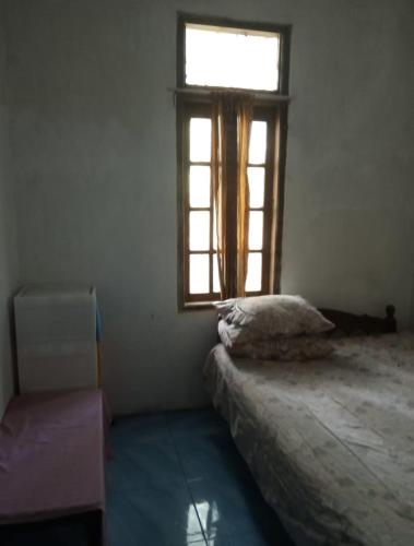 una camera da letto con un letto e una finestra di Sri Homestay a Sermo