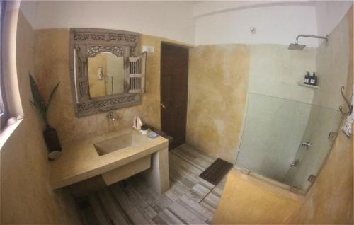 a bathroom with a sink and a mirror at The Spice House Mirissa in Mirissa