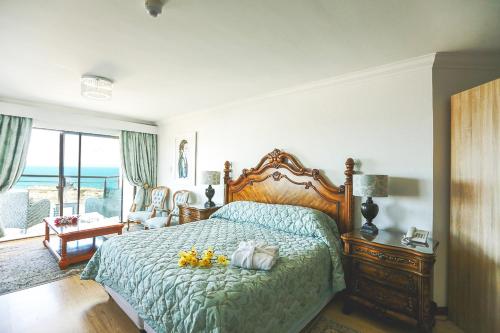 a bedroom with a bed with a blue comforter at Misty Waves Boutique Hotel in Hermanus
