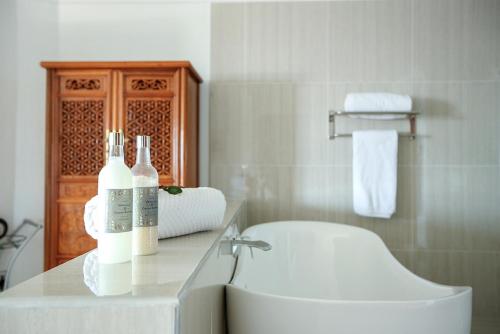 a bathroom with a toilet and a sink with bottles on a counter at Misty Waves Boutique Hotel in Hermanus