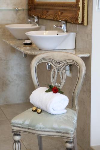 a bathroom with a towel on a chair with a sink at Misty Waves Boutique Hotel in Hermanus