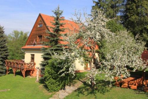 a white house with a red roof and a tree at Chata Horáreň in Smižany