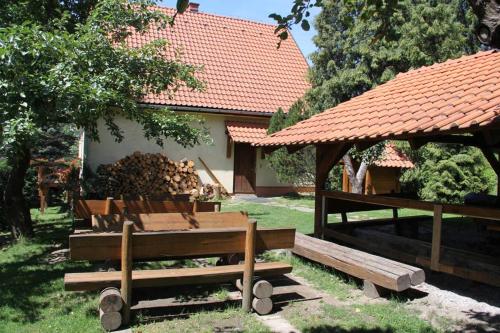 a group of benches in a yard with a gazebo at Chata Horáreň in Smižany