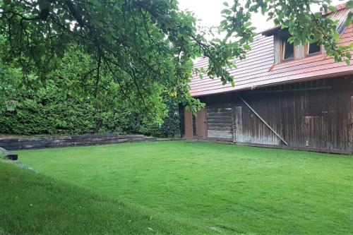 a yard with a fence and a green lawn at Chata Horáreň in Smižany