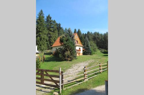 a house in the woods with a fence at Chata Horáreň in Smižany