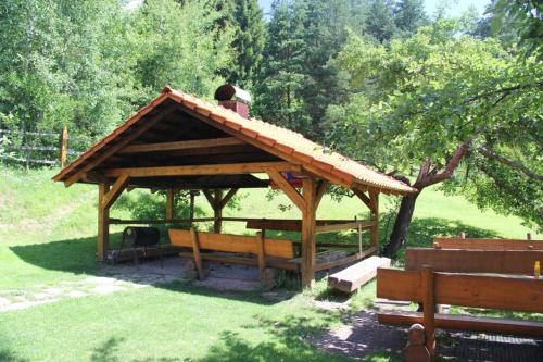 a wooden gazebo with a roof on a field at Chata Horáreň in Smižany