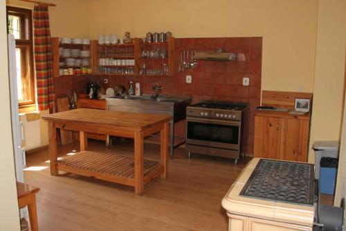 a kitchen with a wooden table and a stove at Chata Horáreň in Smižany