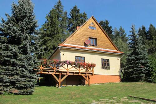 a small house with a balcony in a field at Chata Horáreň in Smižany