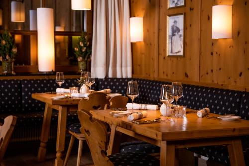 a dining room with wooden tables and wine glasses at Familien- & Gartenhotel Theresia 4-Sterne Superior in Saalbach Hinterglemm