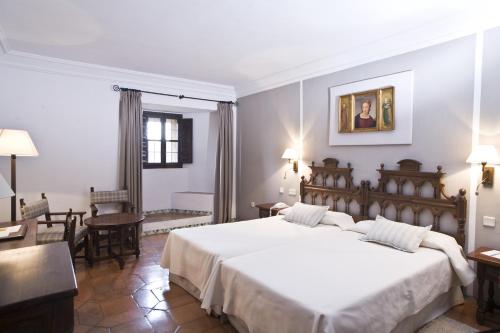 a bedroom with a large white bed in a room at Parador de Siguenza in Sigüenza