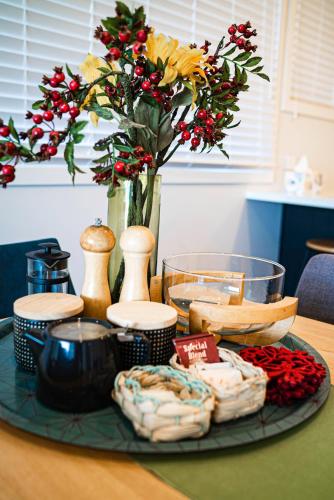 a table with a tray of food and a vase with flowers at Wharf Retreat Unit 2 in Tauranga