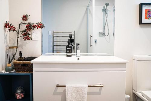 a white bathroom with a sink and a shower at Wharf Retreat Unit 2 in Tauranga