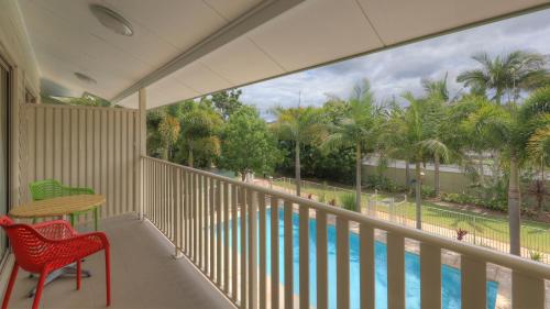 a balcony with a view of a pool and palm trees at Lismore Gateway Motel in Lismore
