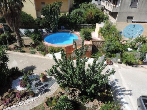 una vista sul giardino con piscina e piante di Villa Marina a Orosei