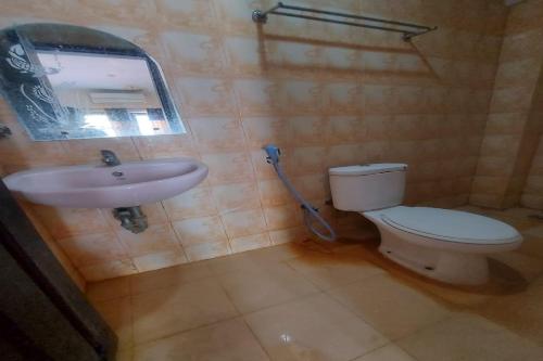 a bathroom with a toilet and a sink at Hotel Mulia Kendari Mitra RedDoorz in Pipulu