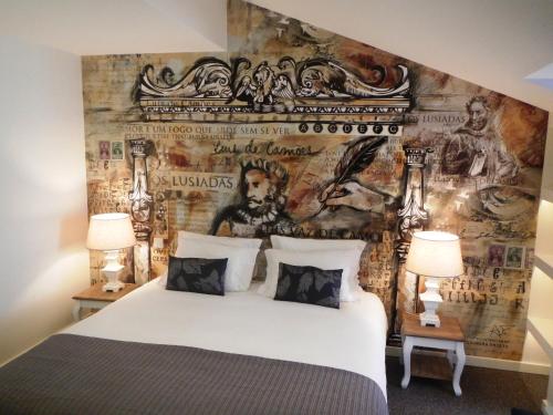 a bedroom with a large bed and a wall with a mural at The ART INN Lisbon in Lisbon