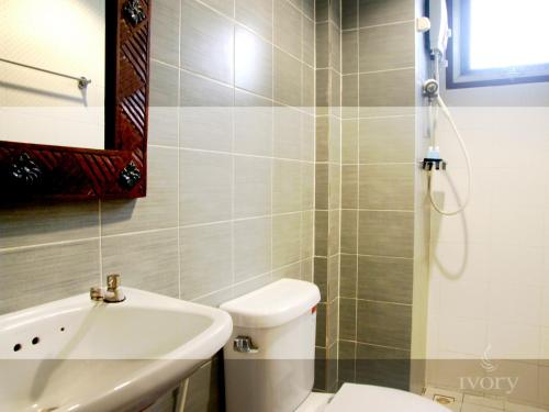 a bathroom with a toilet and a sink and a mirror at Ivory Phi Phi Island in Phi Phi Don