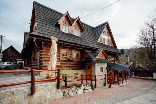 a wooden house with a black roof at Jánošíkova Valaška Hills Apartments in Terchová