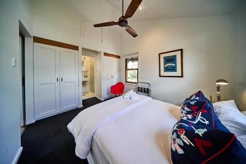 a bedroom with a large white bed and a ceiling fan at The Bronte Boutique Hotel in Morpeth