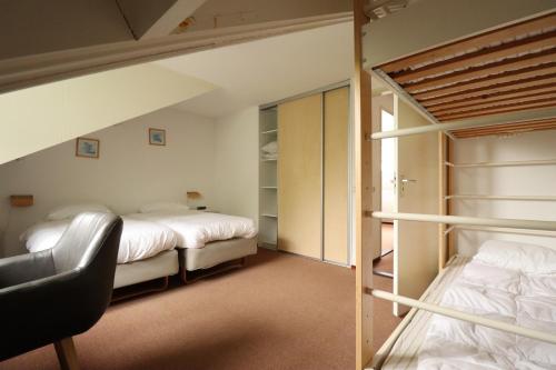 a bedroom with two bunk beds and a chair at Vakantiewoningen Ons Krijtland in Epen