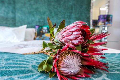 a red flower sitting on top of a bed at Misty Waves Boutique Hotel in Hermanus