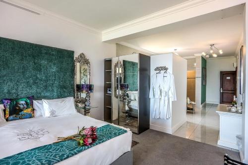 a bedroom with a large bed and a bathroom at Misty Waves Boutique Hotel in Hermanus
