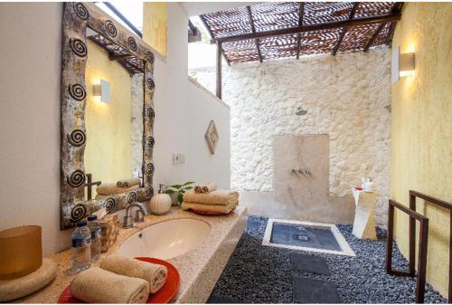 a bathroom with a large mirror and a tub at Villa Bidadari Kutuh Nusa Dua in Nusa Dua