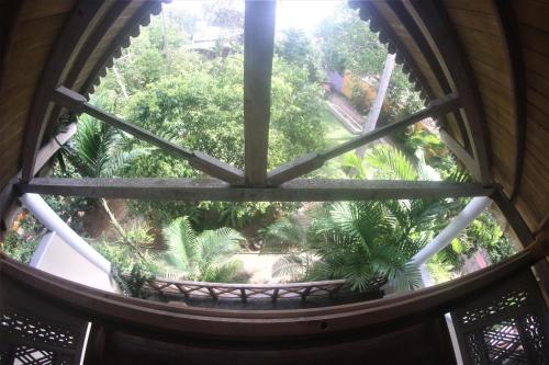 anorthole window of a building with a view of a garden at The Spice House Mirissa in Mirissa