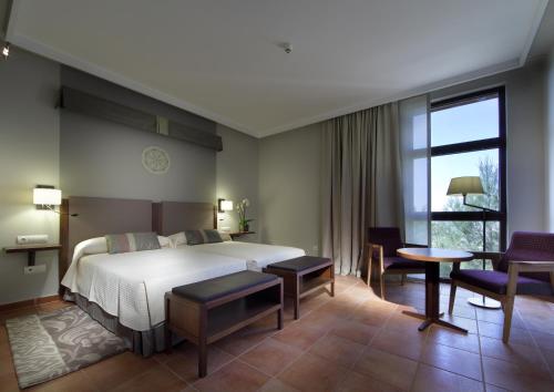 Una habitación de hotel con una cama, una mesa y sillas. en Parador de Lorca, en Lorca