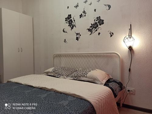 a bedroom with a bed with a lamp and butterflies on the wall at Apartment Pavlyukhina 100 in Kazan