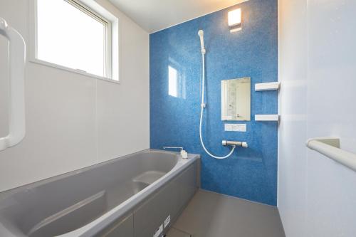 y baño con bañera y lavamanos. en villa PILINA, en Sesoko