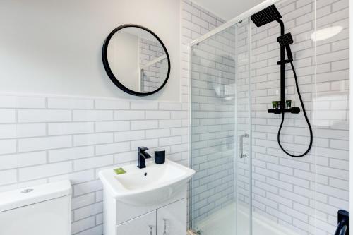 a white bathroom with a sink and a mirror at Bondgate Hotel East Midlands Airport in Castle Donington