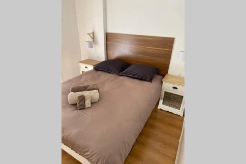 een slaapkamer met een groot bed met een houten hoofdeinde bij Cocon sur cour in Thonon-les-Bains
