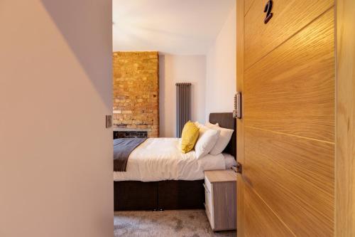 a bedroom with a bed and a brick wall at Bondgate Hotel East Midlands Airport in Castle Donington