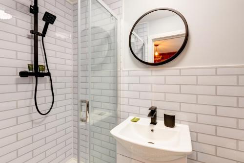 a bathroom with a mirror, sink, and tub at Bondgate Hotel East Midlands Airport in Castle Donington